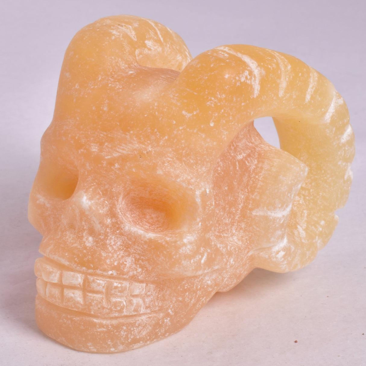 ORANGE CALCITE SKULL WITH RAM HORNS P420